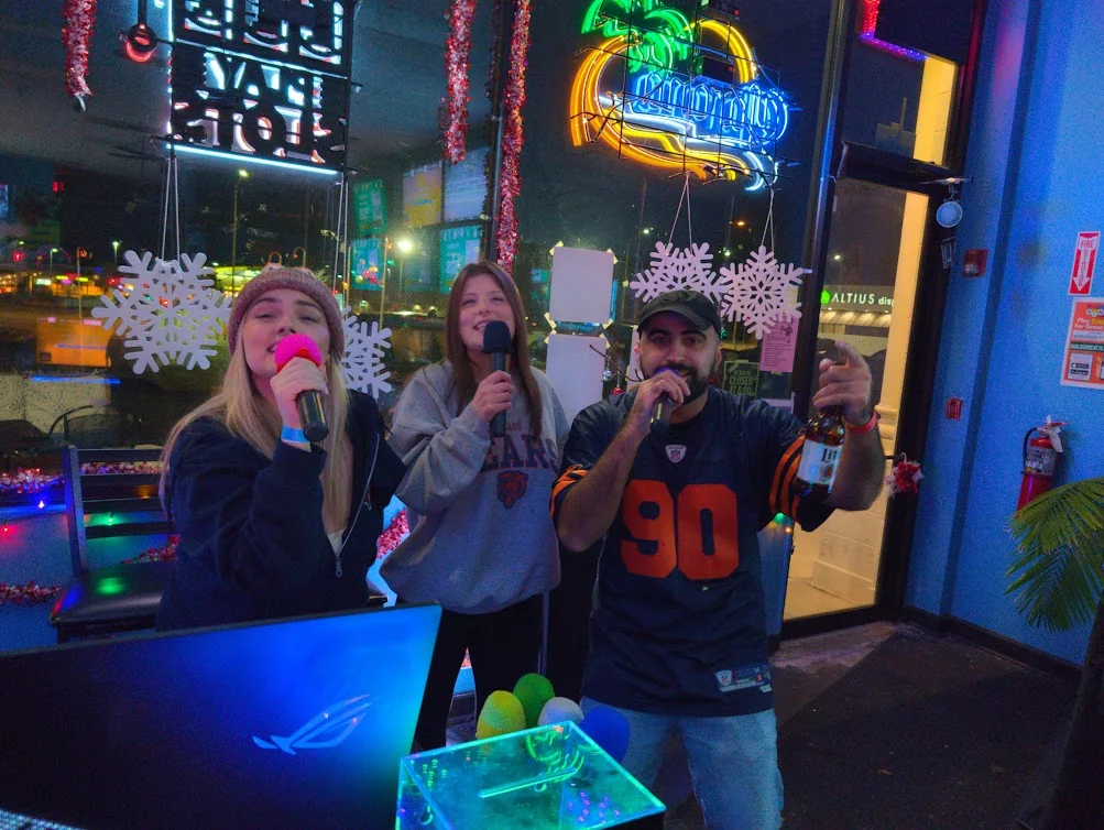 Three guests singing together in the colorful Sam’s Bar and Gaming room